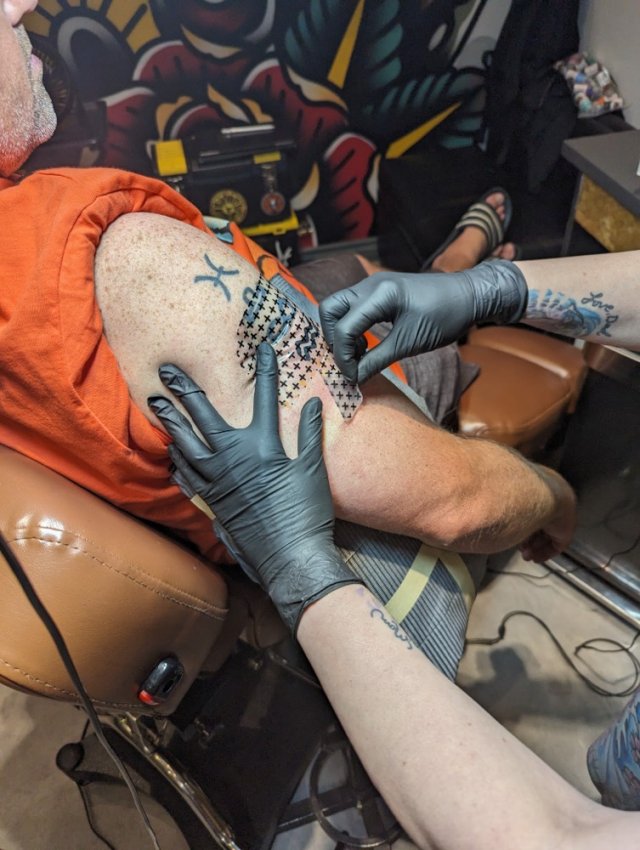 Applying a protective covering to a tattoo.